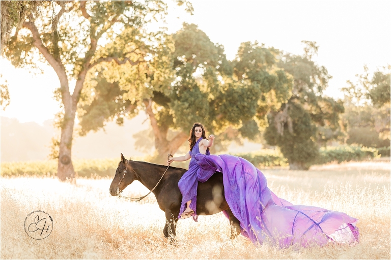 girl wearing a purple parachute dress riding a dark horse in a golden field during an equine photography workshop