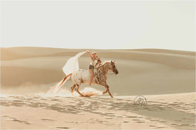 Girl and Appaloosa horse running  at the Pismo Beach Dunes by Elizabeth Hay Photography