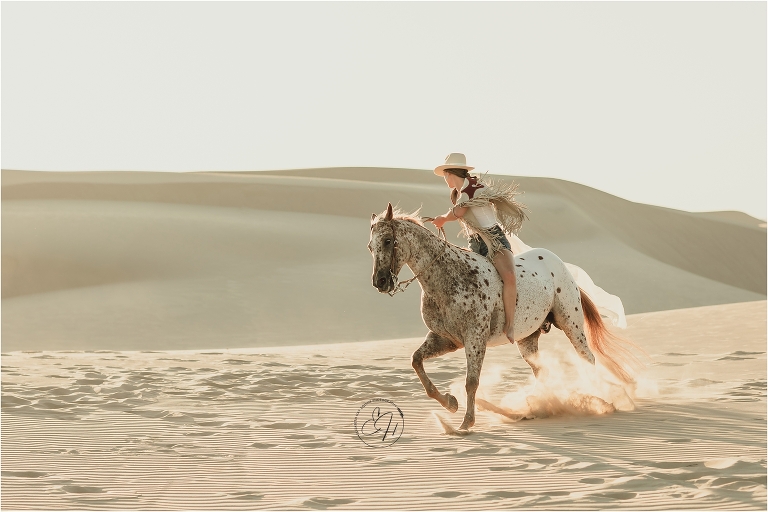 Girl and Appaloosa horse loping at the Pismo Beach Dunes by Elizabeth Hay Photography