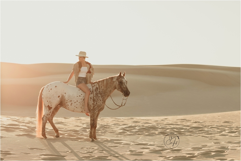 Girl and Appaloosa horse standing at the Pismo Beach Dunes by Elizabeth Hay Photography