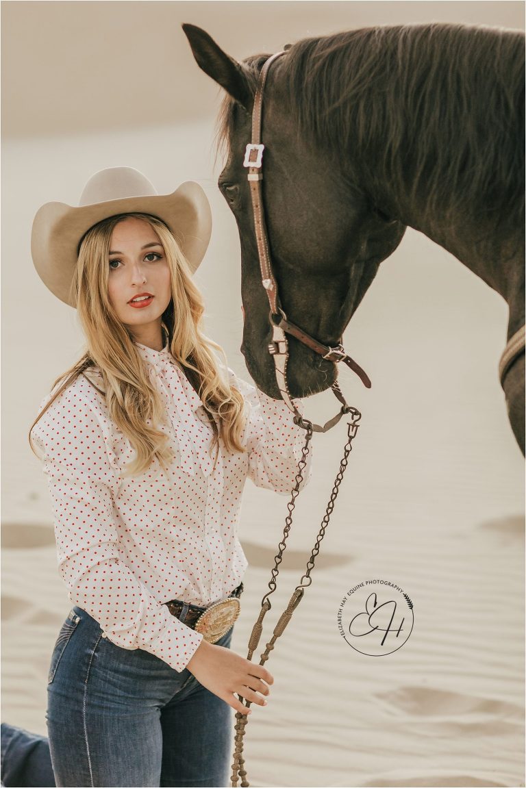 cowgirl kneeling with horse at a high fashion equine shoot at the Pismo Beach Dunes by Elizabeth Hay Photography