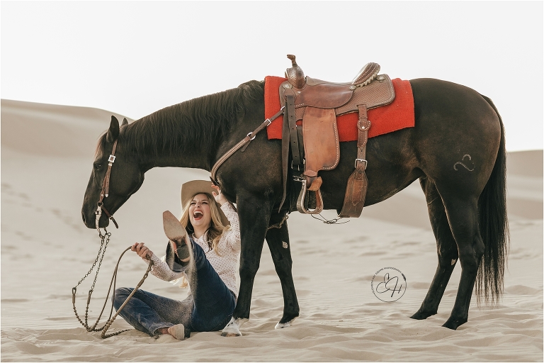 cowgirl laughing with horse at a high fashion equine shoot at the Pismo Beach Dunes by Elizabeth Hay Photography