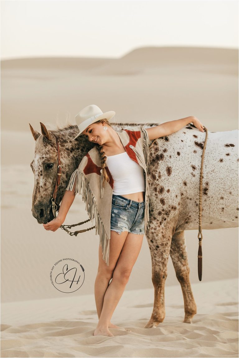 boho cowgirl with horse at a high fashion equine shoot at the Pismo Beach Dunes by Elizabeth Hay Photography