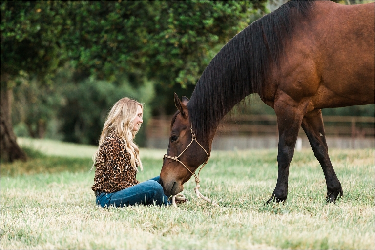 woman sitting and petting bay gelding by California Equine Photographer Elizabeth Hay Photography