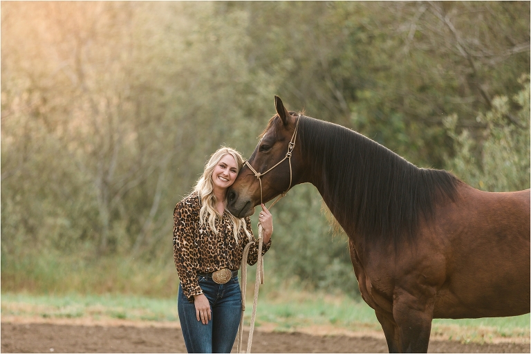 Smiling woman resting cheek on her horse's face during a Morro Bay Equine Photography session by Elizabeth Hay Photography