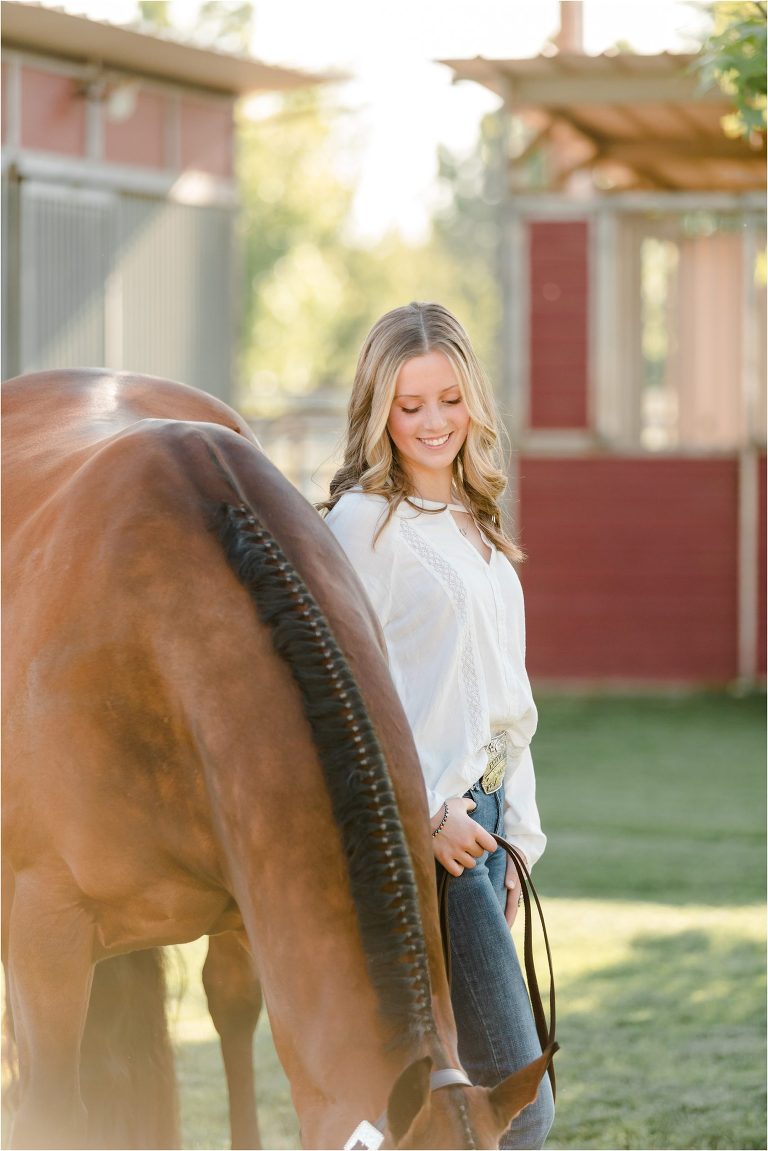 Bakersfield Equine Photography Session with California Equine Photographer Elizabeth Hay of blonde girl and bay gelding eating grass.