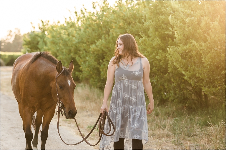 California Equine Photography Session of girl and her horse walking in an orchard by Elizabeth Hay Photography. 