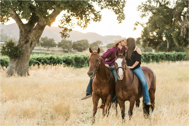 Cowboy and girl riding together and kissing by California Equine Photographer, Elizabeth Hay Photography.