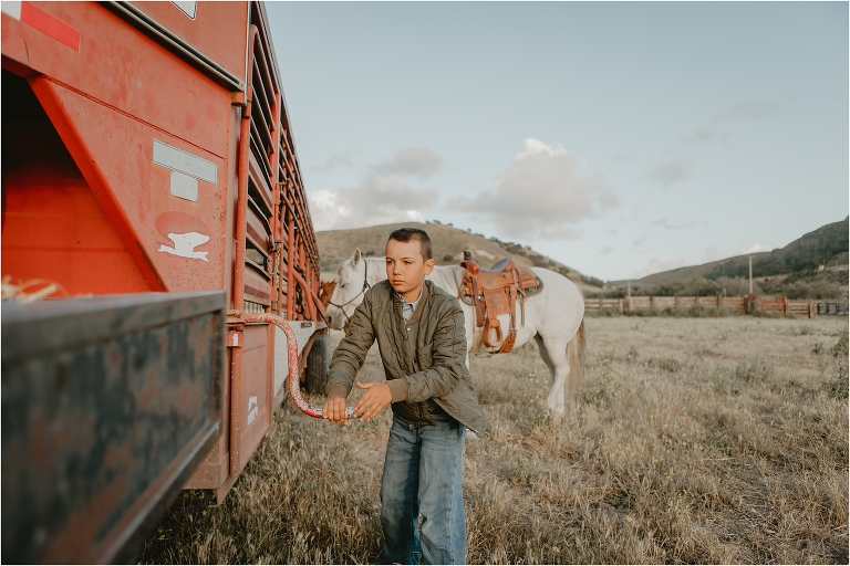 young cowboy hooking up a horse trailer with his dad