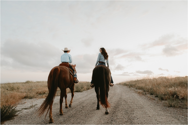 mother and son ride off down a ranch trail together at sunset by Elizabeth Hay Photography