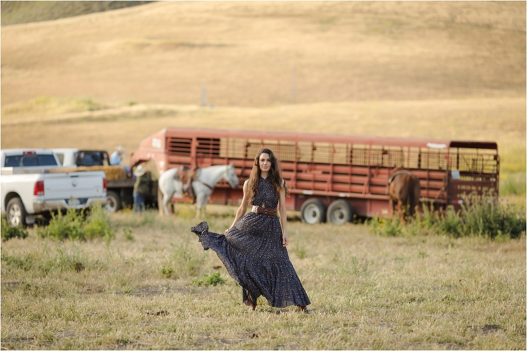 Lindsay Branquinho in a field with horse trailer parked in the background by California Equine Photographer Elizabeth Hay Photography