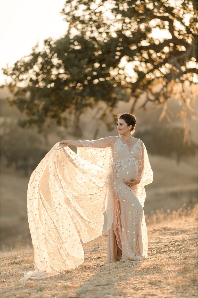 pregnant woman wearing a nude colored star print dress by Elizabeth Hay Photography