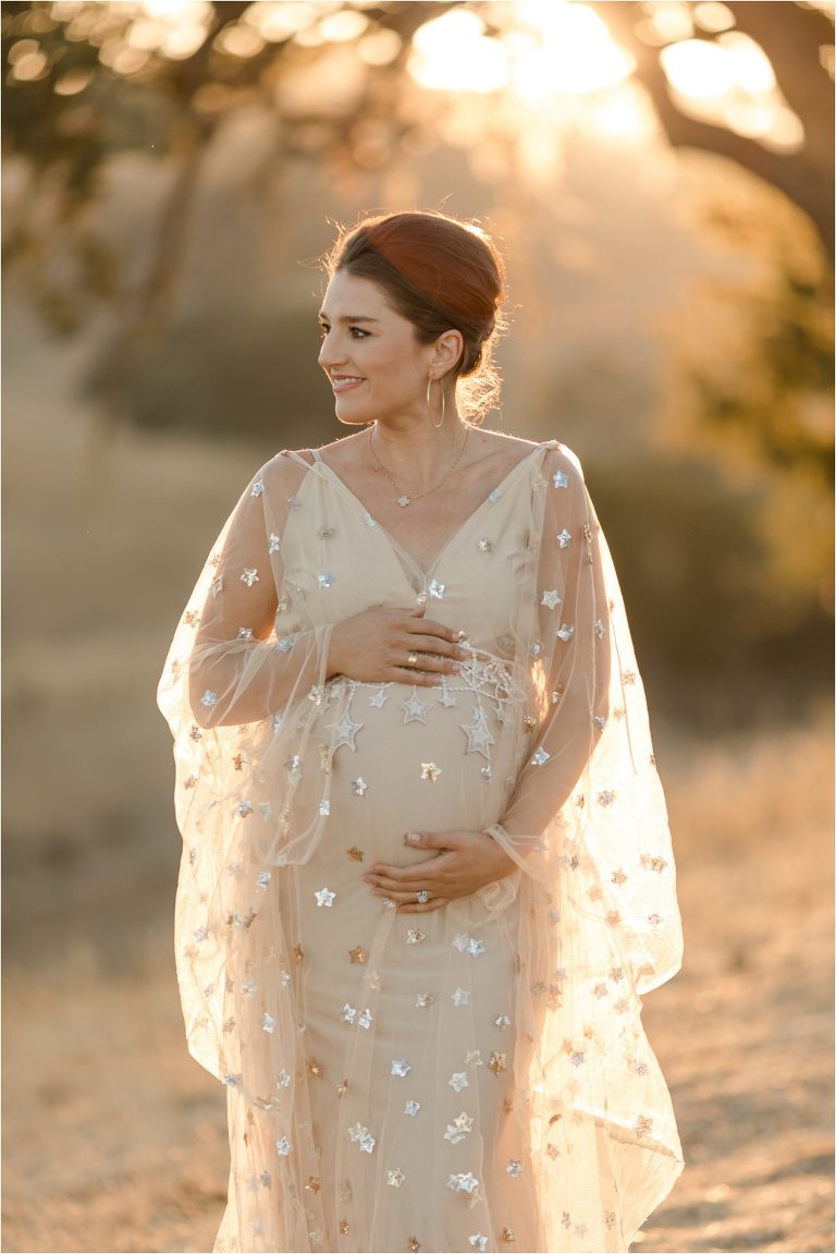 pregnant woman wearing a nude colored star print dress by Elizabeth Hay Photography