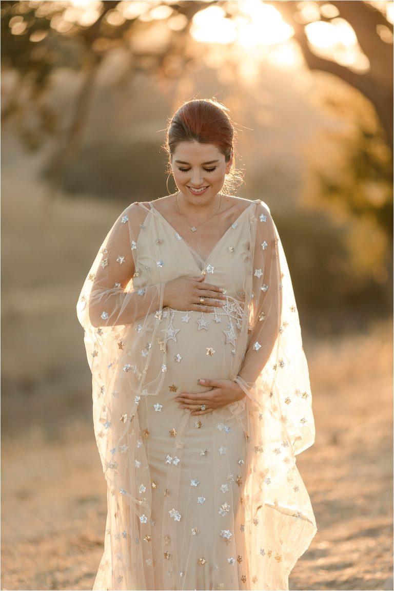 pregnant woman wearing a nude colored star print dress by Elizabeth Hay Photography