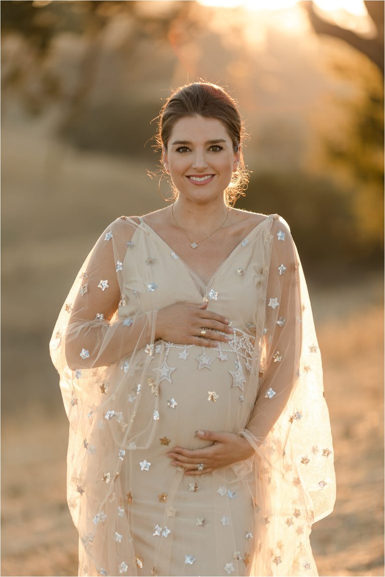 pregnant woman wearing a nude colored star print dress by Elizabeth Hay Photography