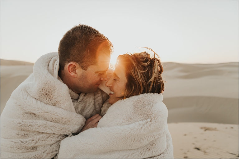 couple wrapped in a blanket at Pismo Beach Dunes by Elizabeth Hay Photography