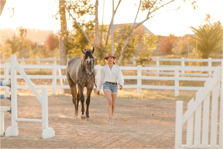 Taylor and her grey show jumper gelding walking through jumps by California Equine Photographer, Elizabeth Hay Photography