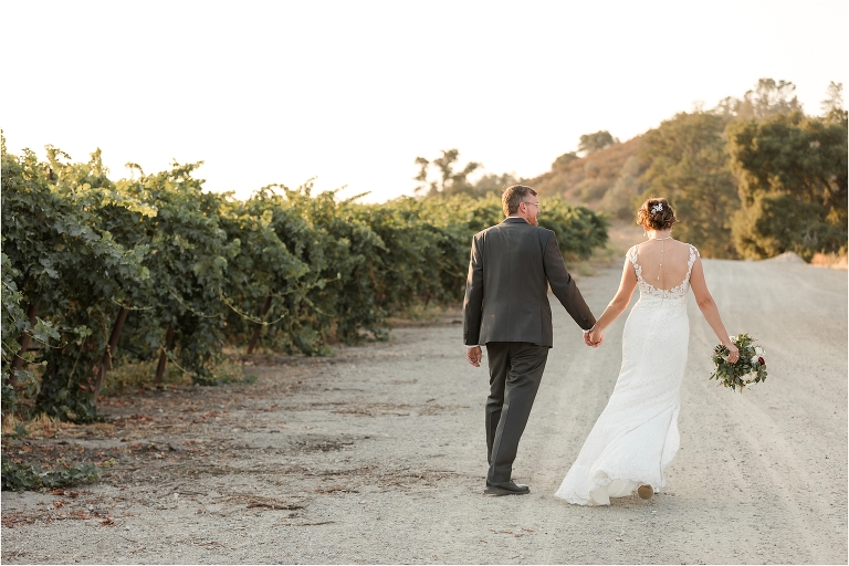 couple walks through a vineyard Oyster Ridge Elopement wedding at a California Winery