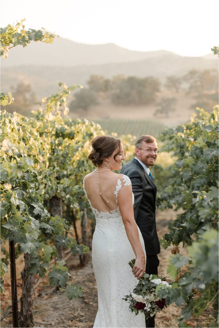 bride and groom walks through a vineyard Oyster Ridge Elopement wedding at a California Winery
