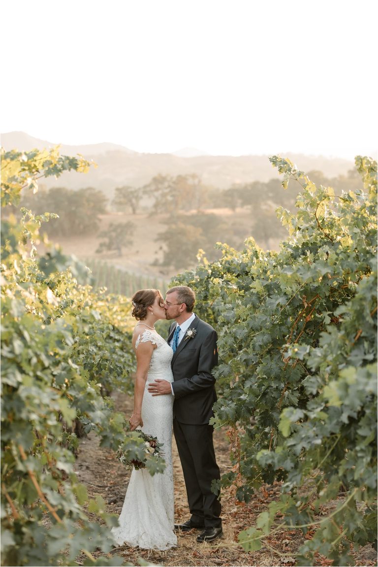 bride and groom kiss in a vineyard Oyster Ridge Elopement wedding at a California Winery