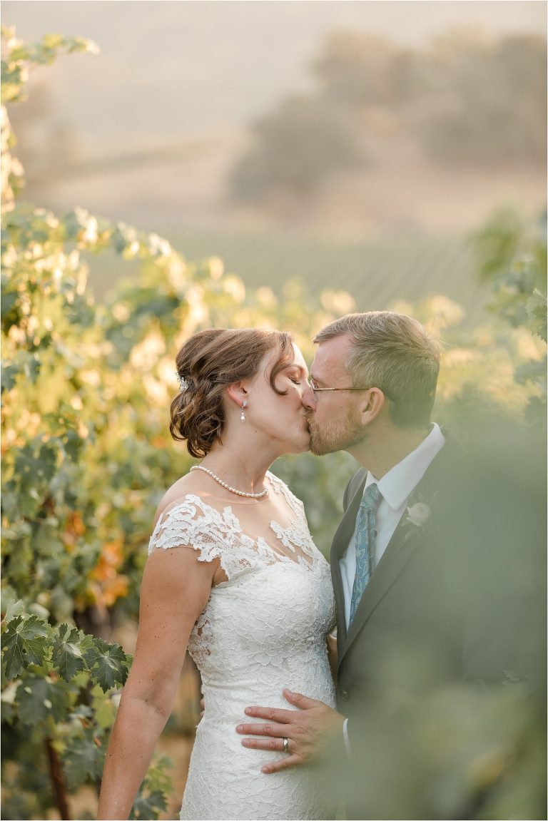 newly married bride and groom kiss in a vineyard Oyster Ridge Elopement wedding at a California Winery