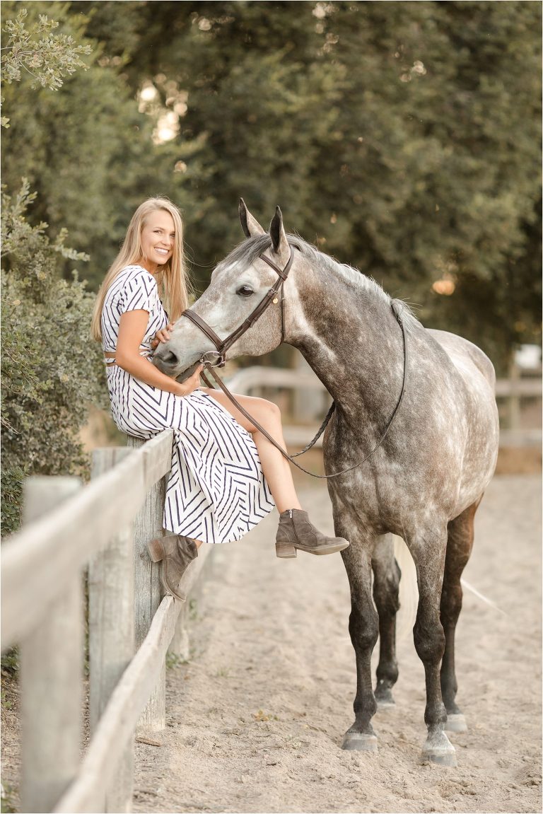 blonde girl sitting on arena fence with grey gelding by California Equine Photographer Elizabeth Hay Photography at Oak Park Equestrian Center. 