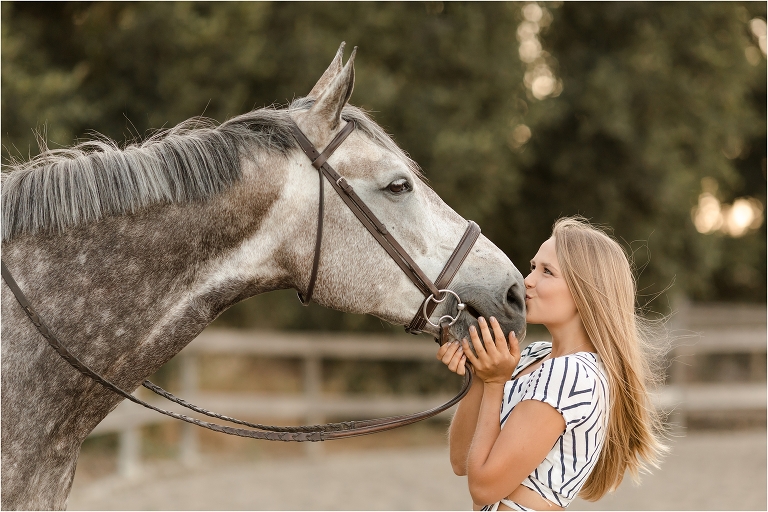 blonde girl kissing her grey gelding by California Equine Photographer Elizabeth Hay Photography at Oak Park Equestrian Center. 