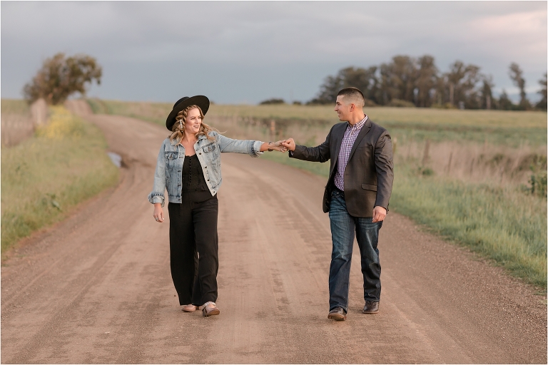 couple walking on road during Western Engagement session by Elizabeth Hay Photography