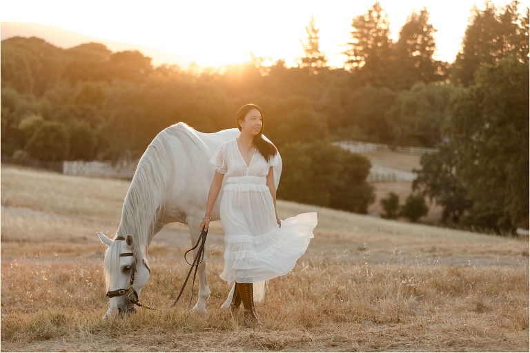 woman wearing cream colored Ulla Johnson dress at sunset with Lusitano gelding by California Equine Photographer Elizabeth Hay Photography
