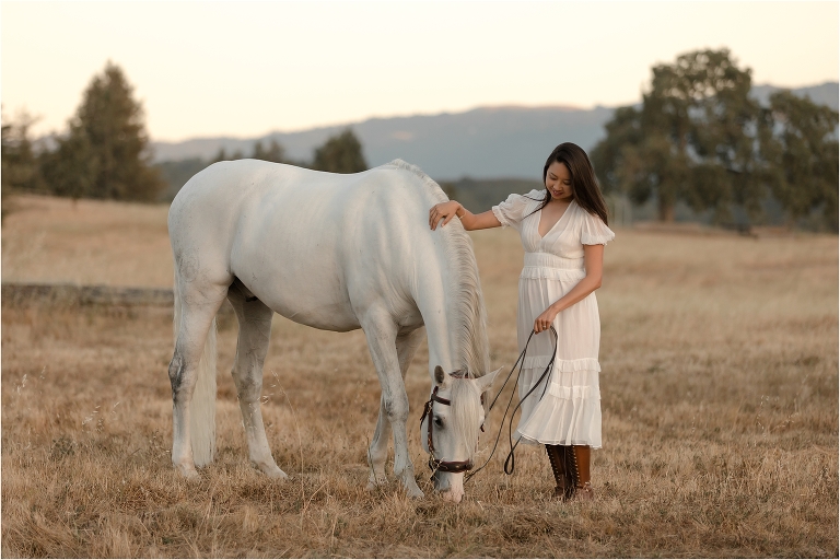 woman petting her white Lusitano gelding by California Equine Photographer Elizabeth Hay Photography