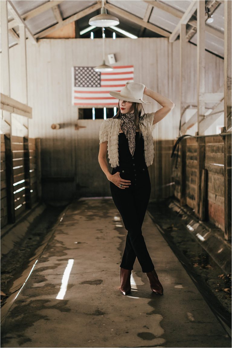 Western Fashion Style Inspo on the farm with Lindsay Branquinho in an old dairy barn aisle and an American Flag by Elizabeth Hay 