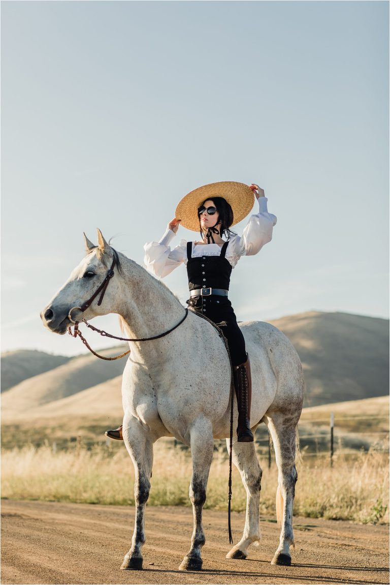 woman wearing black overalls with grey horse on county back road by California Equine Photographer Elizabeth Hay Photography