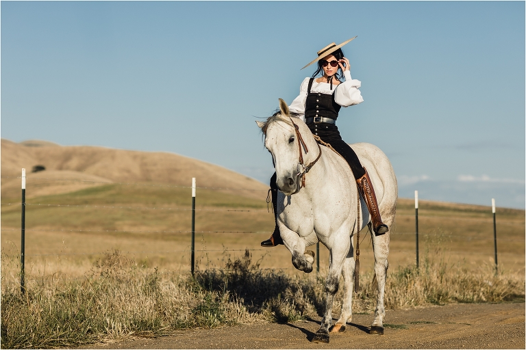 woman wearing black overalls and riding boots with grey mare on county back road by California Equine Photographer Elizabeth Hay 
