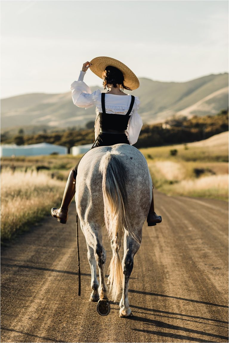 woman riding grey horse on county back road by California Equine Photographer Elizabeth Hay 