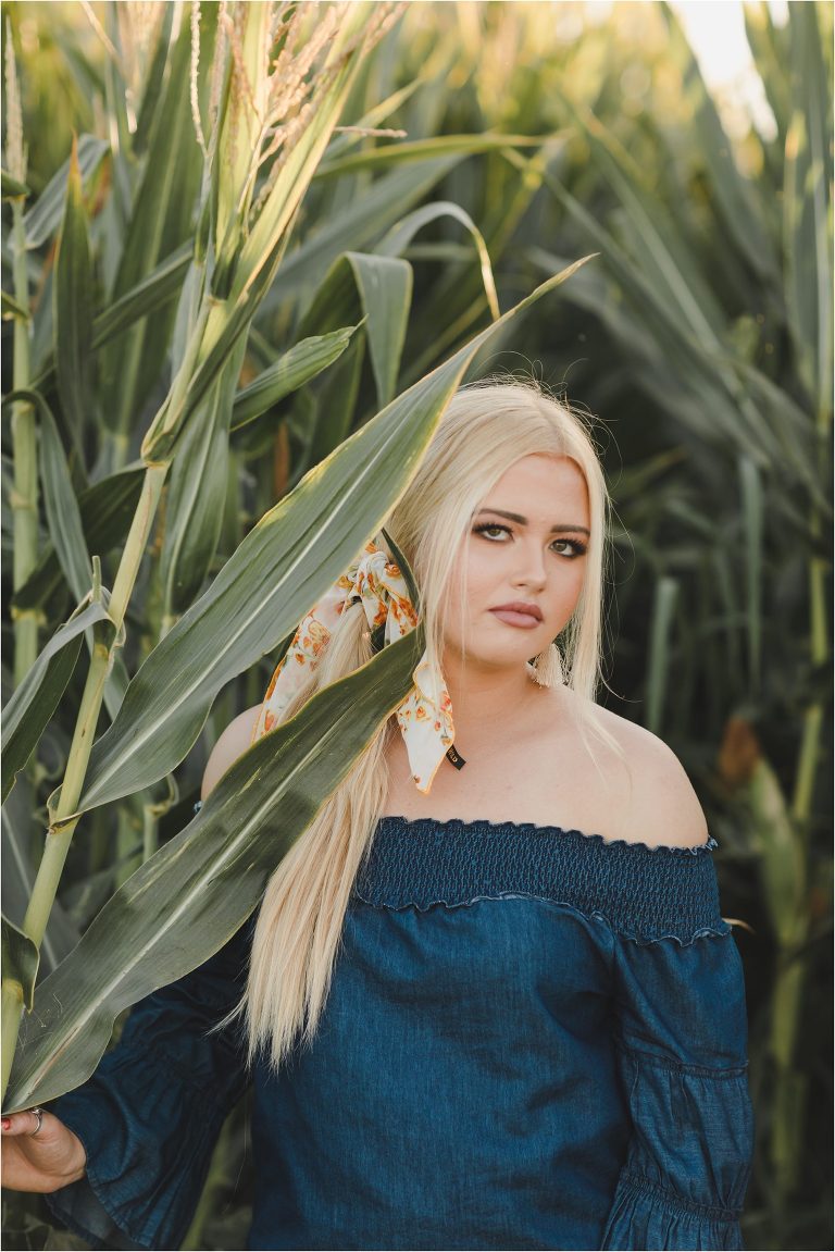 Blonde girl wearing denim top and orange and white floral wild rag in a corn field by California Equine Photographer Elizabeth Hay Photography.
