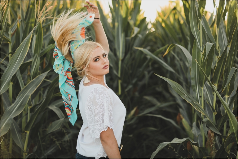 Blonde girl wearing white top and teal tribal print wild rag in a corn field by California Equine Photographer Elizabeth Hay Photography.