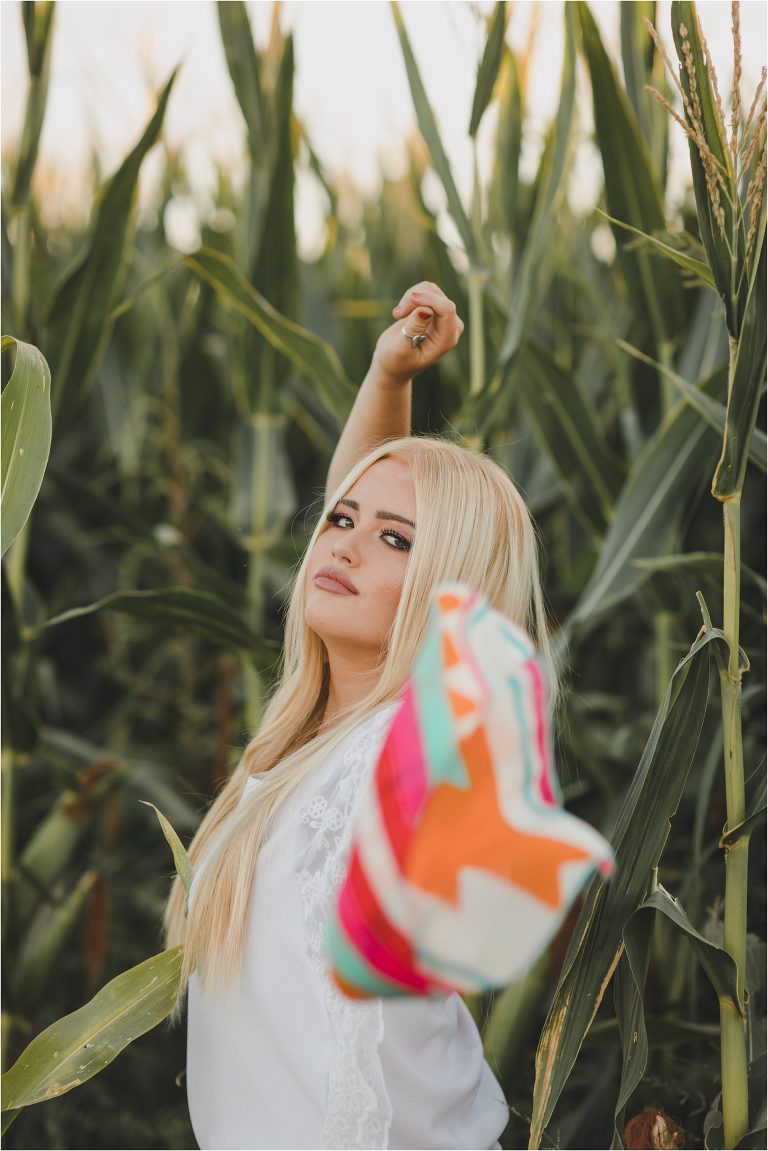 Blonde girl wearing white top and multi-colored print wild rag in a corn field by California Equine Photographer Elizabeth Hay Photography.