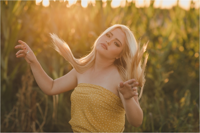 Blonde girl wearing a yellow polka dot wild rag as a top in a corn field by California Equine Photographer Elizabeth Hay Photography.