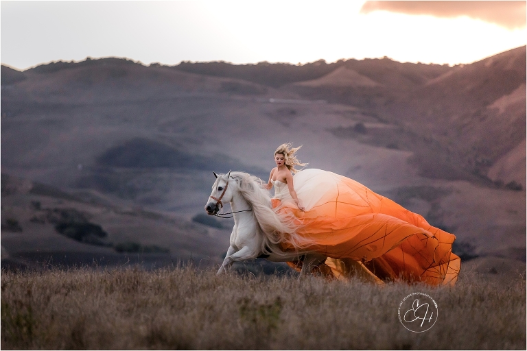 woman wearing orange parachute dress while riding an Andalusian horse shot by California Equine Photographer Elizabeth Hay Photography. 