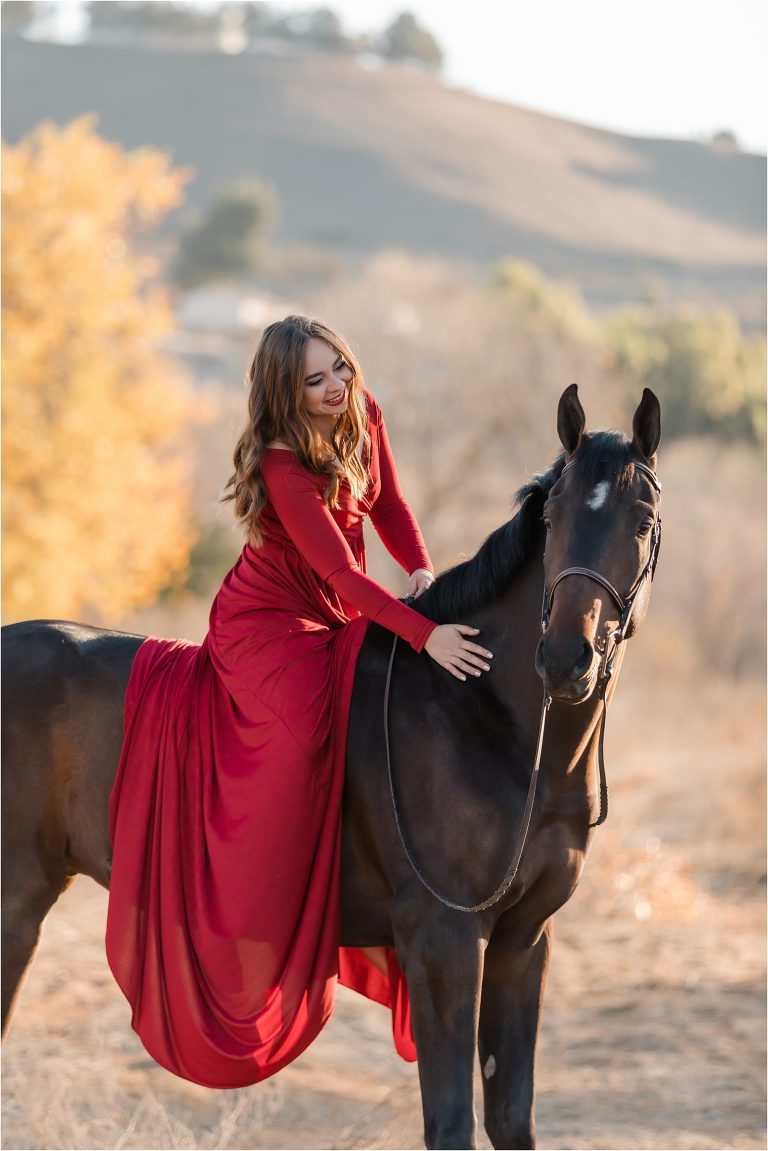 California Horse Photography Shoot at Wheeler Performance Horses in Hollister California by Elizabeth Hay Photography of girl petting horse and wearing a red dress. 